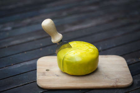 Dutch pesto cheese slices on a wooden background in a closeup view.の写真素材