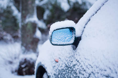 Consumer car covered by snow in a winter day.の写真素材