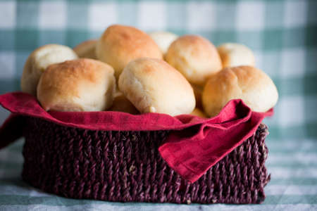 Small buns or bread are served in a wooden basketの写真素材