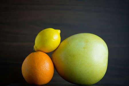 Citrus fruits include pomelo, lime, and orange are mix in a closeup view.