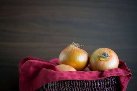 Bulb onion in a closeup view in front of a wooden backgroundの写真素材
