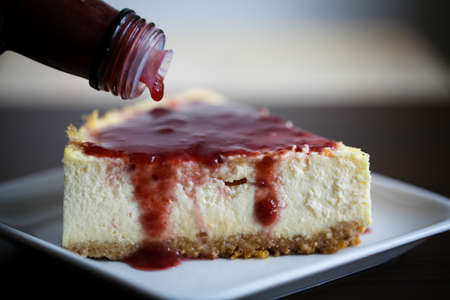 New York style cheesecake slice with raspberry syrupの写真素材