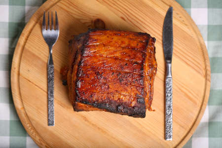 Piece of roasted pork on a wooden board in a closeup viewの写真素材
