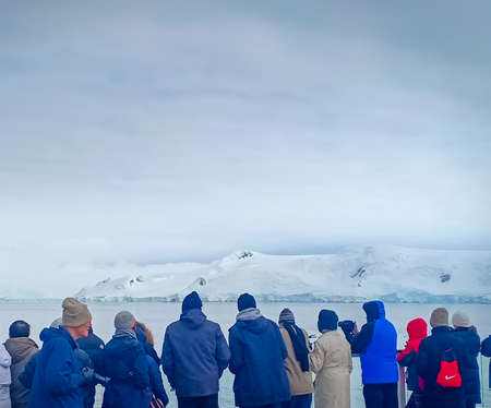 a group of people watching glacier in Antarcticaの写真素材