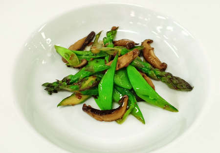 stir fried mushrooms and asparagus in a serving plateの写真素材
