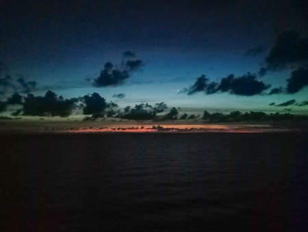 sunset in ocean and moody cloudy skyの写真素材