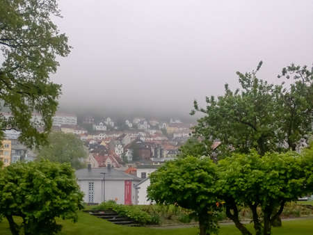 a view of beautiful houses in norway bergan partially covered in fogの写真素材