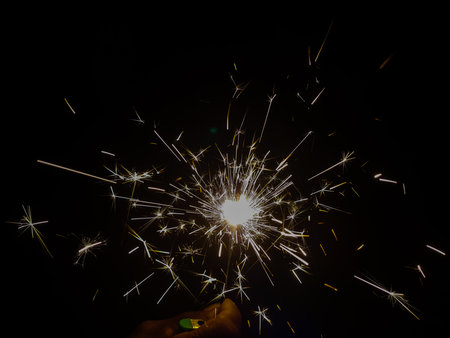 Burning sparkler producing spark around, celebration with fireworks and crackers during X mas and...