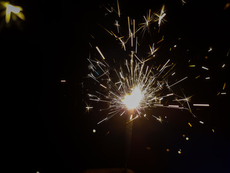 Burning sparkler producing spark around, celebration with fireworks and crackers during X mas and new yearの写真素材