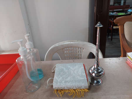 holy water sprinkler stole and hand sanitizer on a table in a Christian church in keralaの写真素材