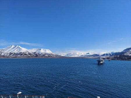 Serene Winter Landscape: Majestic Mountains, Pristine Snow, and Tranquil Sea a view from svalbard and jan mayen norwayの写真素材