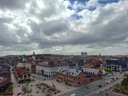 denmark aalborg june 11 2024 Aerial view of a vibrant city square featuring historic buildings, busy streets, and a cloudy skyline.の写真素材