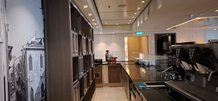 Interior of a contemporary coffee shop featuring a high-quality espresso machine, elegant shelving units, and a welcoming ambiance with tasteful decor and practical workspace for a cozy experience.の写真素材