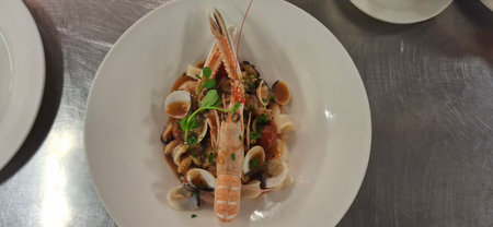 Exquisite culinary dish featuring pasta with a variety of shellfish, garnished beautifully for a sophisticated dining experience. Captures the essence of seafood cuisine and gourmet delight.の写真素材