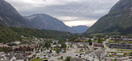 Eidfjord Norway A quaint valley town surrounded by majestic mountains, featuring homes, roads, and lush greenery under a cloudy sky. Perfect depiction of rural beauty and natural landscapes.の写真素材