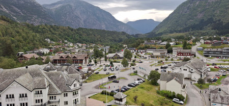 Eidfjord Norway A quaint valley town surrounded by majestic mountains, featuring homes, roads, and lush greenery under a cloudy sky. Perfect depiction of rural beauty and natural landscapes.の写真素材