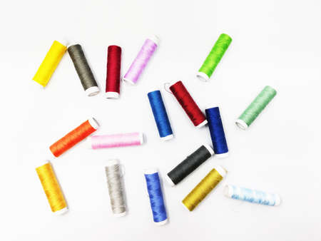 Colorful sewing threads stacked over white background. Perfect for wallpaper.