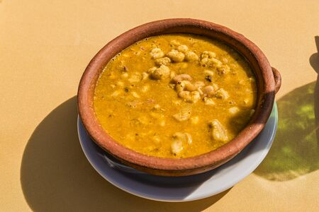 Locro, typical Argentine food, accompanied by bread and a glass of wine, with spoons.の写真素材