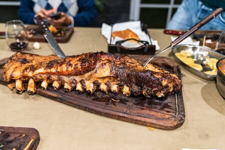 "Parrillada" Argentine barbecue make on live coal (no flame), beef "asado", bread, "Chorizo" and Grilled beef ribs with a hot rack, close up, focus selectの写真素材