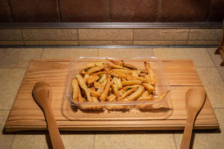 Homemade grilled chicken served on a ceramic white plate with with rustic fried potatoes and sauce....
