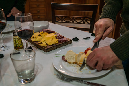 Table with variety of typical Italian appetizer, cold cuts and knife, on a rustic wooden table....