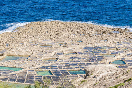 Salt evaporation ponds, also called salterns or salt pans located near Qbajjar on the maltese Island of Gozo.の写真素材