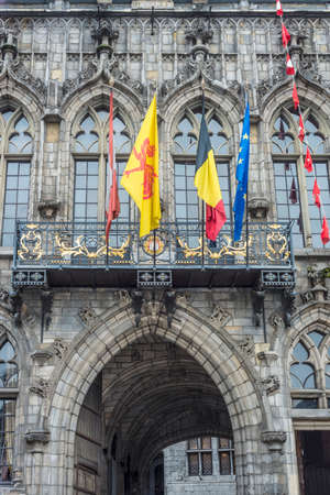 Flags waving on City Hall building facade in Mons, capital of the Wallonian province of Hainaut in Belgium.のeditorial素材