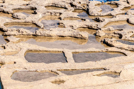 Salt evaporation ponds, also called salterns or salt pans located near Qbajjar on the maltese Island of Gozo.の写真素材