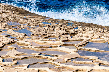 Salt evaporation ponds, also called salterns or salt pans located near Qbajjar on the maltese Island of Gozo.の写真素材