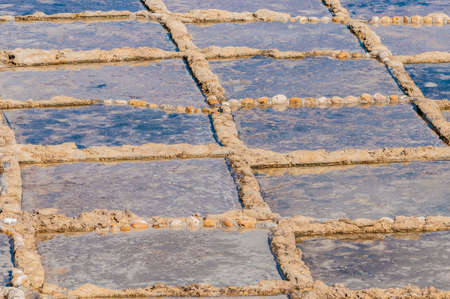 Salt evaporation ponds, also called salterns or salt pans located near Qbajjar on the maltese Island of Gozo.のeditorial素材