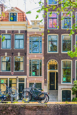 Ancient architecture example represented in this old houses facades on Amsterdam bank canal, Netherlands.のeditorial素材
