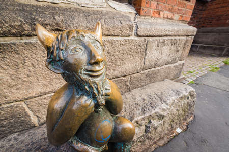 Cute little devil sitting on a stone outside Marienkirche (St. Mary s Church) in Luebeck,...