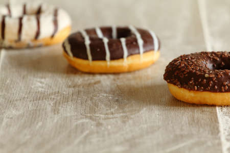 black and white chocolate donuts on wooden tableの写真素材