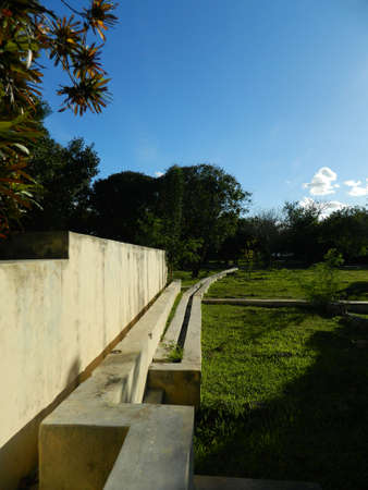 An beautiful garden space with nice architecture lit by the sun during a quiet afternoonの写真素材