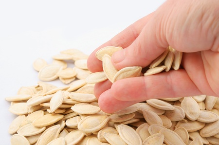 Pumpkin seeds in hand on white backgroundの写真素材