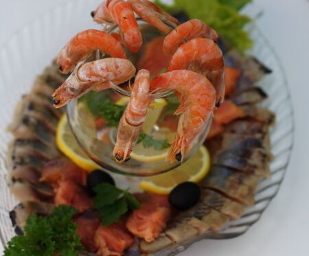  Boiled shrimps with lemon and parsley on a platter with an assortment of fish dishes.                          の写真素材
