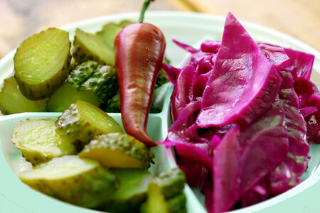 Pickled vegetables - cucumbers, cabbage, pepper lie on a white plate.の写真素材