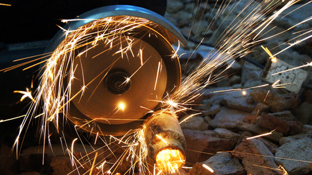 The sparks fly from under the cutting of construction tools.
