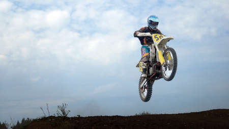 The athlete motorcyclist participant of the competitions on the Moto-execute a jump on the background of blue skyのeditorial素材