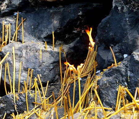 Lighted candles at the foot of the rock memory.の写真素材