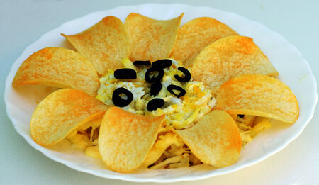 Chicken salad from a chicken fillet ,cheese and onion laid on a plate decorated with chips.の写真素材