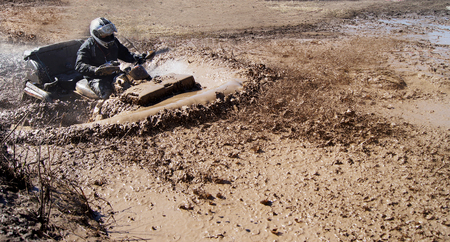 Extreme driving ATV on overcoming mud obstacles.