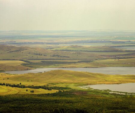 The lake is located at the foot of the mountains from the height of bird flight.の写真素材