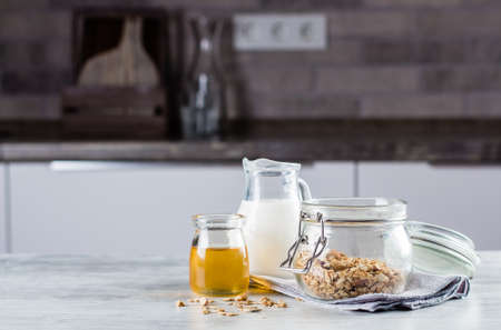 Breakfast food concept. Homemade granola, milk or yogurt and honey on table background on the kitchen. Copyspace for textの写真素材