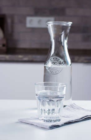Glass of pure water and bottle on kitchen table. Clean concept, copyspace for textの写真素材