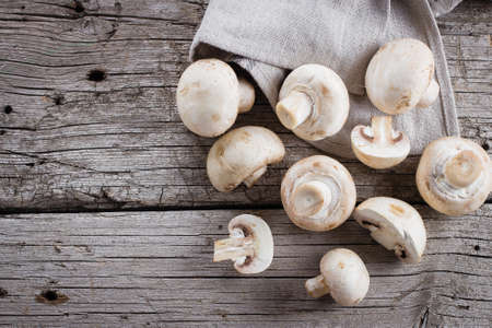 Fresh mushrooms champignons on a wooden background. Autumn Harvest Food Vegetarian Vegetable. Top View, Copy Spaceの写真素材