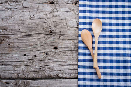 Blue checkered tablecloth and spoon on wooden rustic table background. Copy space, top viewの写真素材