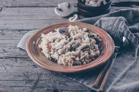 Italian pasta fusili with mushrooms and cream sauce on wooden table, copy space, top view. Autumn Food Conceptの写真素材
