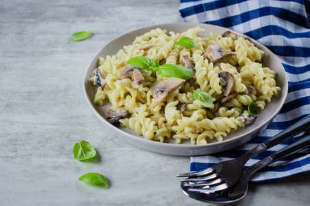 Pasta Fusili with mushrooms, sause cream and basil on stone concrete table. Italian Food Concept. Top view, copy spaceの写真素材