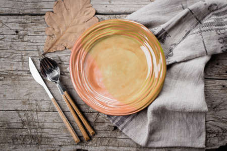 Seasonal Autumn table setting with fallen leaf and cutlery. Top view, copy spaceの写真素材